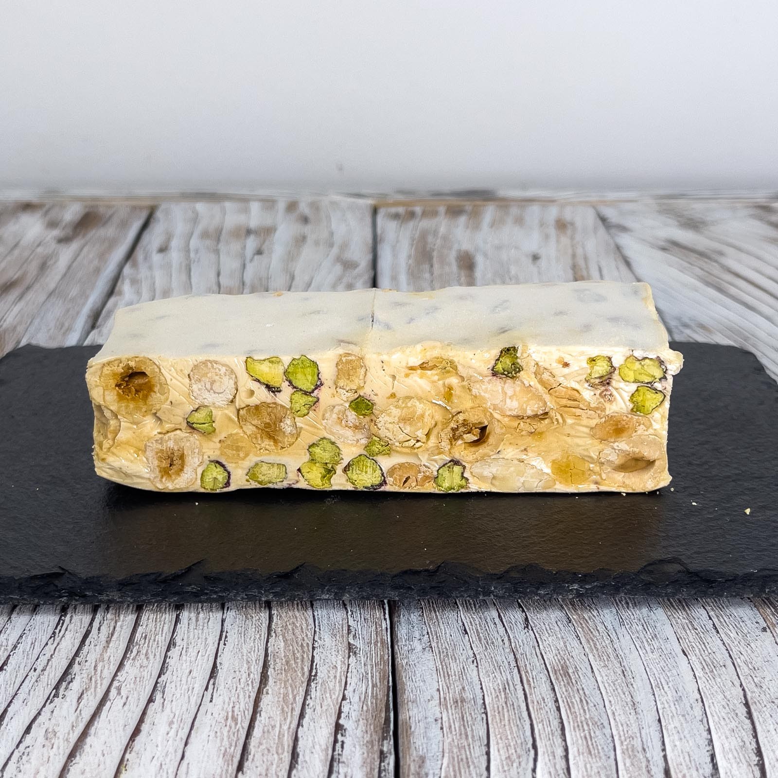 “Torrone” is a typical Christmas dessert, made from egg white, honey and sugar, almonds and with the addition of pistachios and hazelnuts.