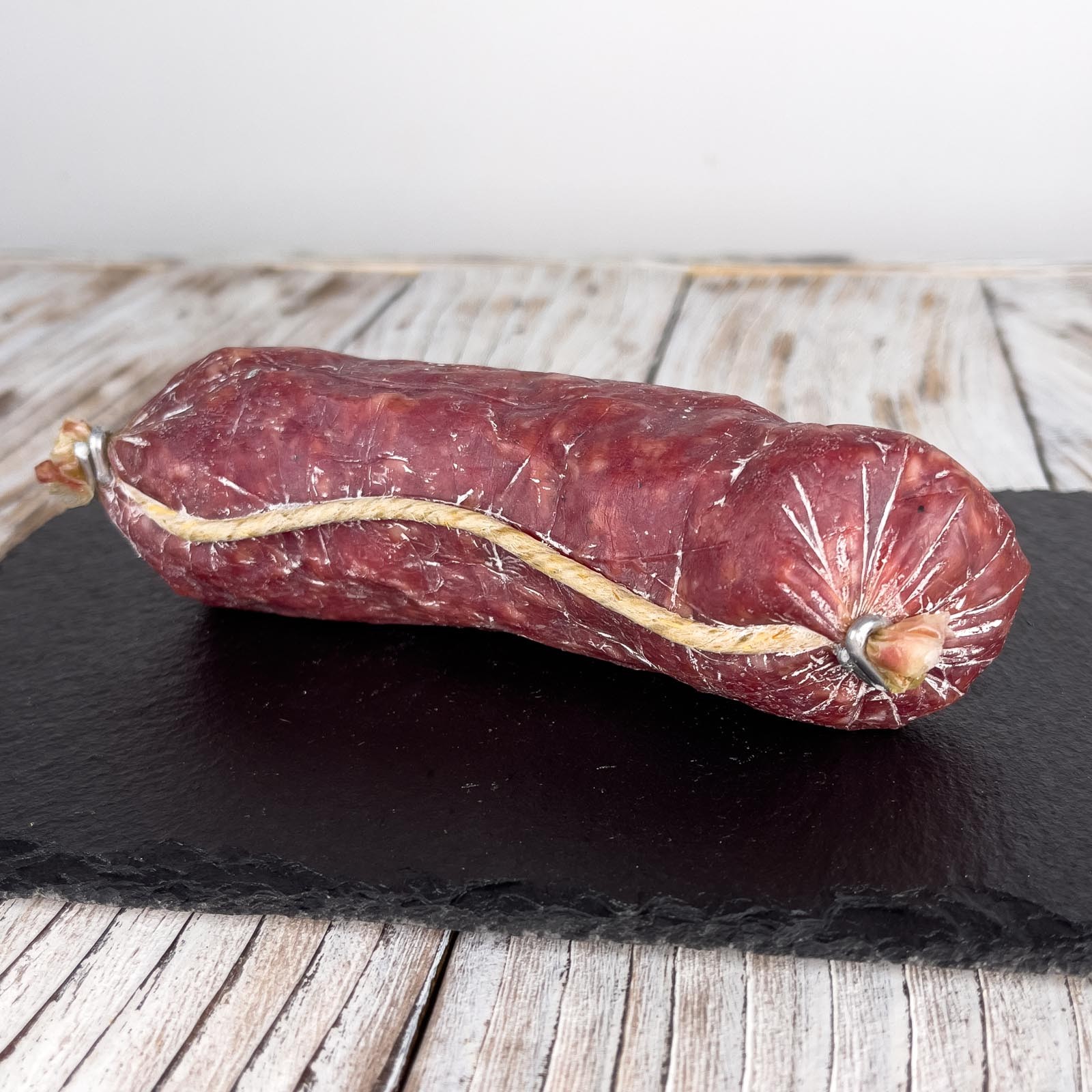 Garlic Salami is a traditional medium-ground artisan salami flavored with garlic, stuffed into natural pork casing, tied by hand and seasoned naturally.